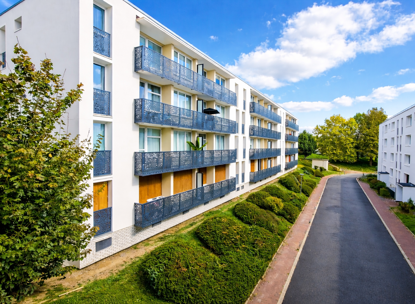 Façades rénovées de la copropriété Les Vingt Arpents à Crosne, entourée d'espaces verts